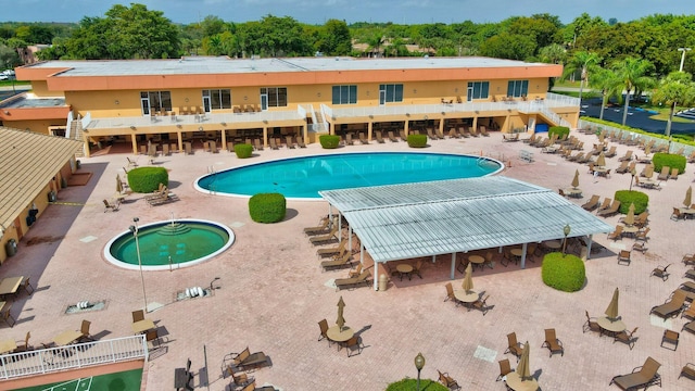 view of pool with a patio area and a hot tub