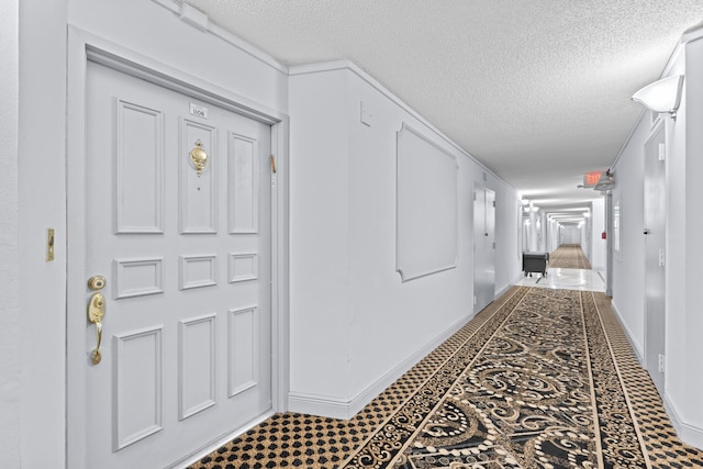 corridor with a textured ceiling and tile patterned floors