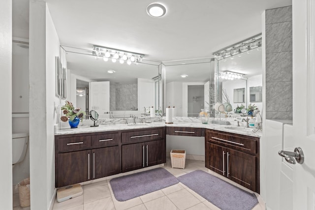 bathroom with tiled shower, vanity, and tile patterned floors