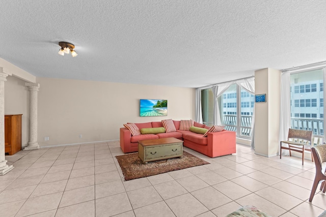 tiled living room featuring floor to ceiling windows, decorative columns, and a textured ceiling