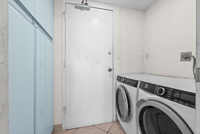 laundry area featuring washer and dryer and light tile patterned floors