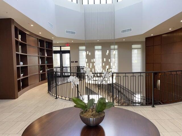 hall with light tile patterned floors and a high ceiling