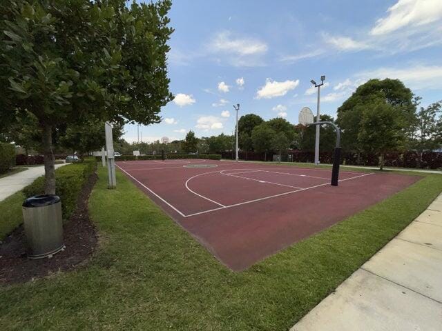 view of sport court featuring a lawn