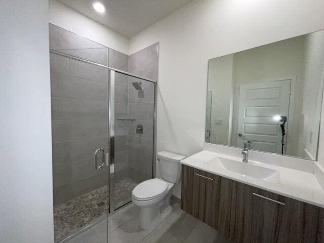 bathroom featuring vanity, toilet, and walk in shower