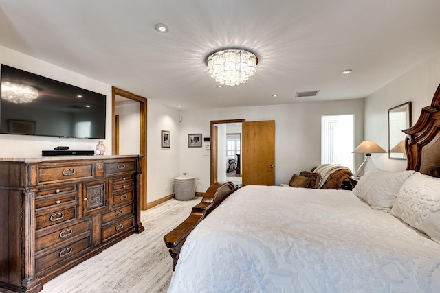 bedroom with light hardwood / wood-style flooring and a chandelier