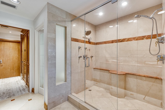 bathroom with a shower with shower door and tile patterned floors