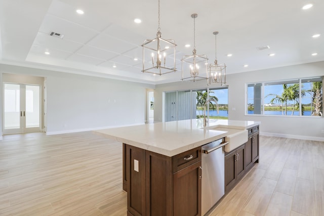 kitchen with sink, light hardwood / wood-style flooring, dishwasher, a kitchen island with sink, and decorative light fixtures