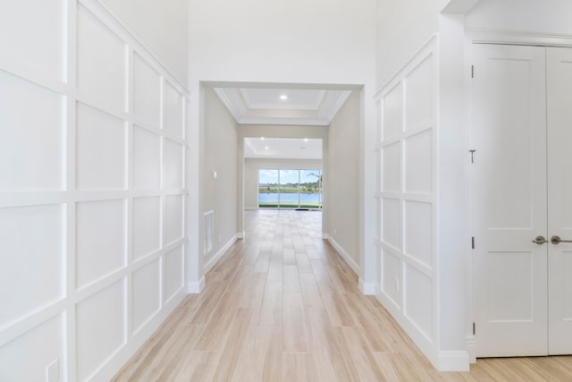 corridor with crown molding and light hardwood / wood-style flooring