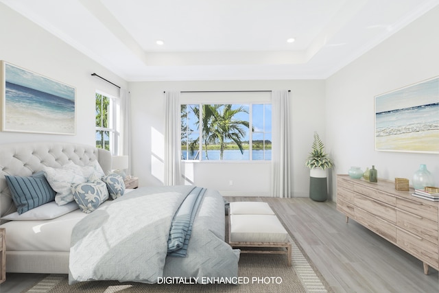 bedroom featuring crown molding, hardwood / wood-style floors, and a tray ceiling