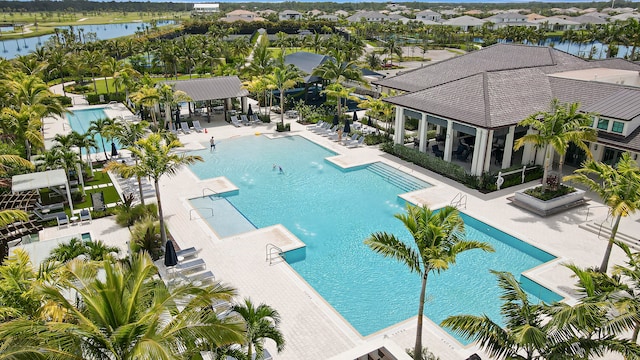 view of pool with a gazebo, a water view, a patio area, and a pergola