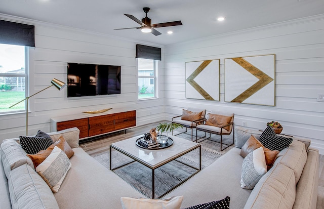 living room with crown molding, ceiling fan, and light hardwood / wood-style floors