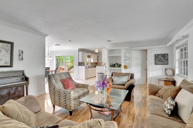 living room featuring light wood-type flooring, ornamental molding, and a chandelier