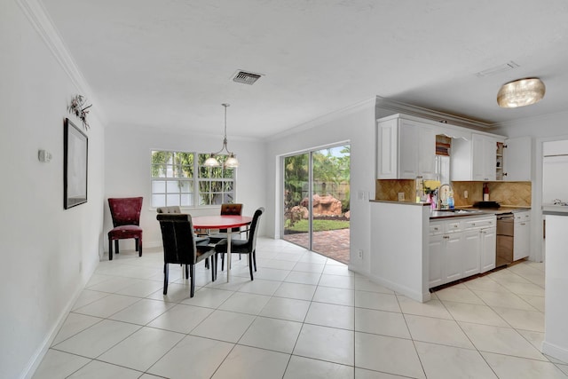 tiled dining area with a chandelier, crown molding, and sink