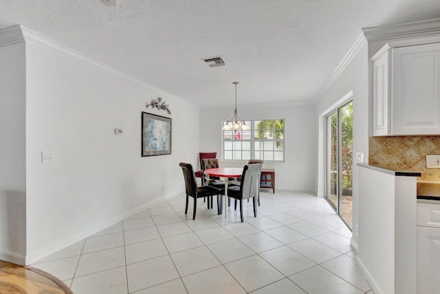 dining space with ornamental molding, a chandelier, and light tile patterned floors