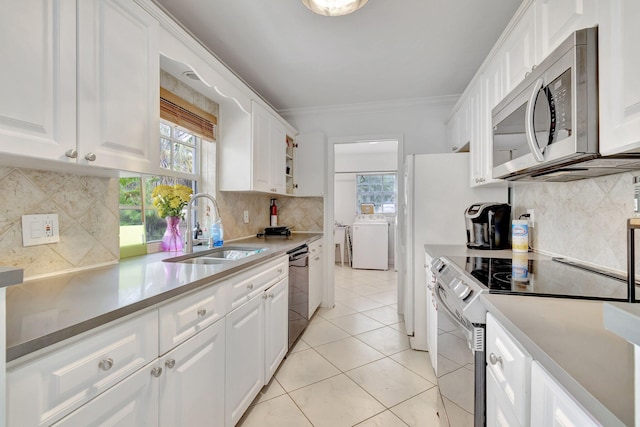 kitchen featuring ornamental molding, light tile patterned floors, stainless steel appliances, sink, and white cabinets