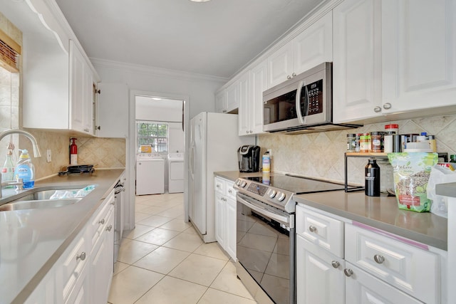 kitchen featuring white cabinetry, sink, stainless steel appliances, and washer and clothes dryer