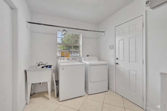 clothes washing area featuring washing machine and clothes dryer and light tile patterned floors