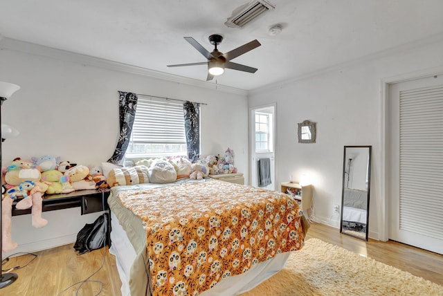 bedroom with light wood-type flooring, ceiling fan, and ornamental molding