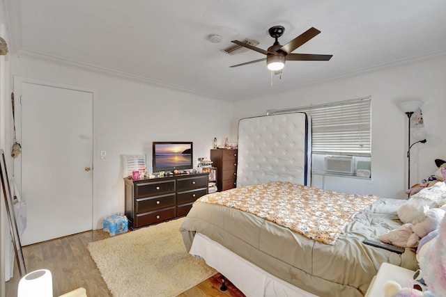 bedroom with cooling unit, light hardwood / wood-style flooring, ceiling fan, and ornamental molding