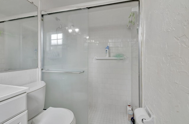 bathroom with a shower with door, vanity, and toilet