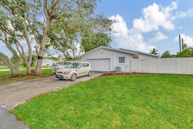 view of front facade with central AC, a garage, and a front lawn