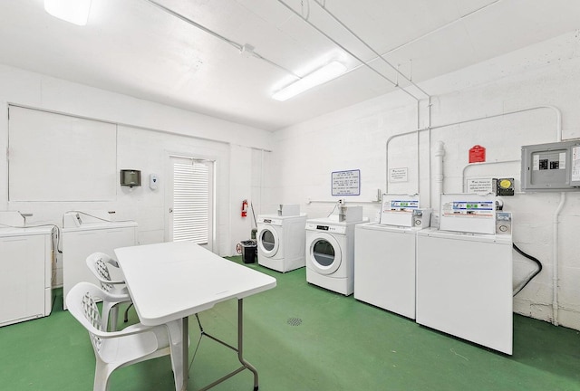 clothes washing area featuring electric panel and separate washer and dryer