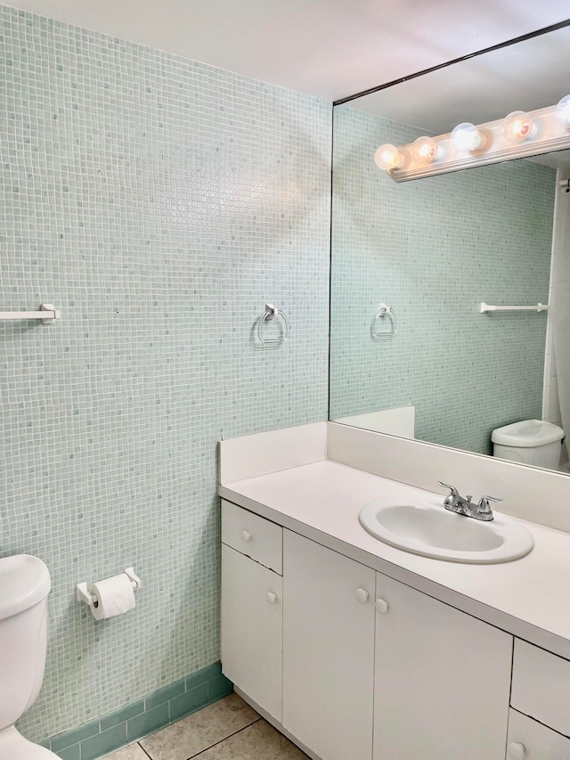 bathroom featuring vanity, toilet, tile walls, and tile patterned floors