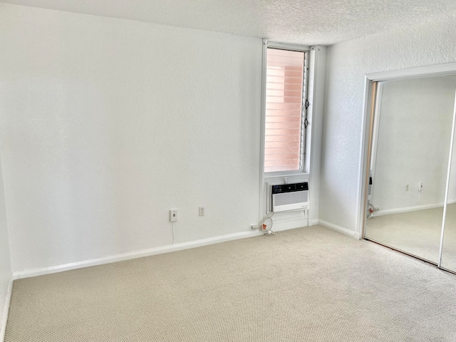 carpeted spare room with a textured ceiling