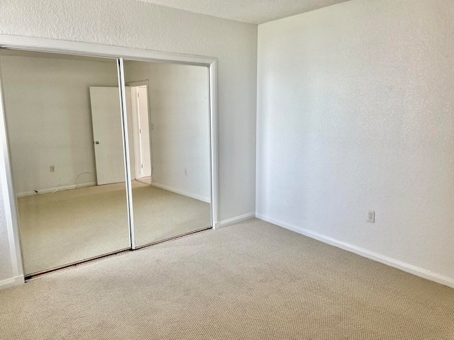 unfurnished bedroom with a closet and carpet floors