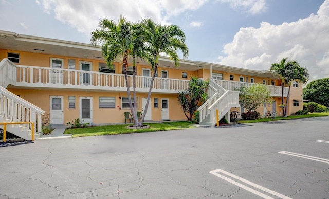 108 NE 20th Ave Unit 205, Boynton Beach, FL 33435 - view of building exterior featuring stairway and uncovered parking
