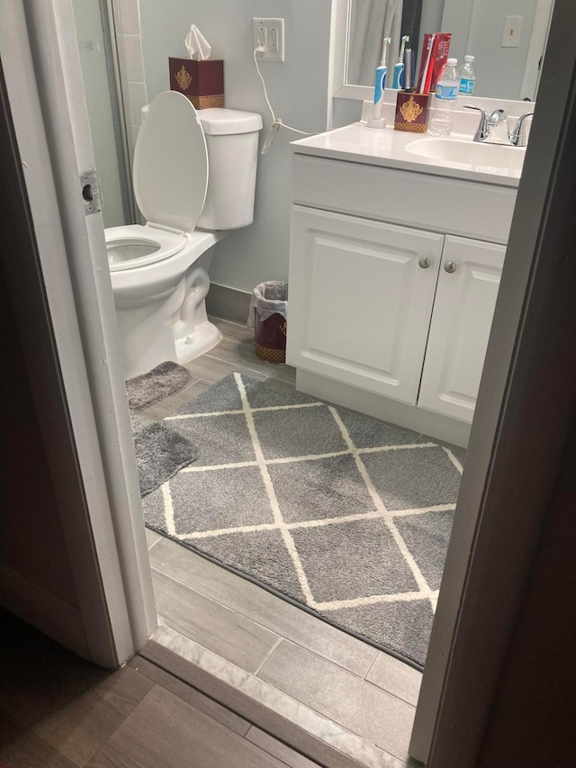 bathroom with vanity, hardwood / wood-style flooring, and toilet