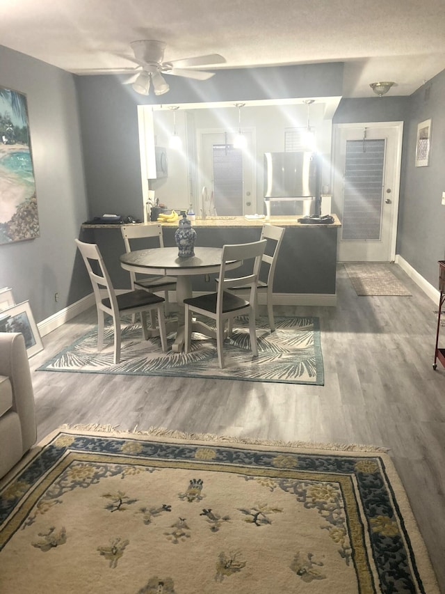 dining space with hardwood / wood-style flooring and ceiling fan