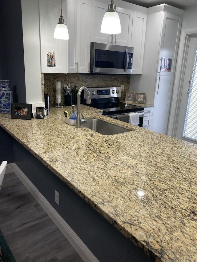 108 NE 20th Ave Unit 205, Boynton Beach, FL 33435 - kitchen featuring appliances with stainless steel finishes, baseboards, light stone countertops, and wood finished floors