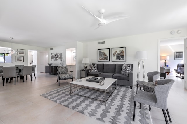 living room with light tile patterned flooring and ceiling fan with notable chandelier