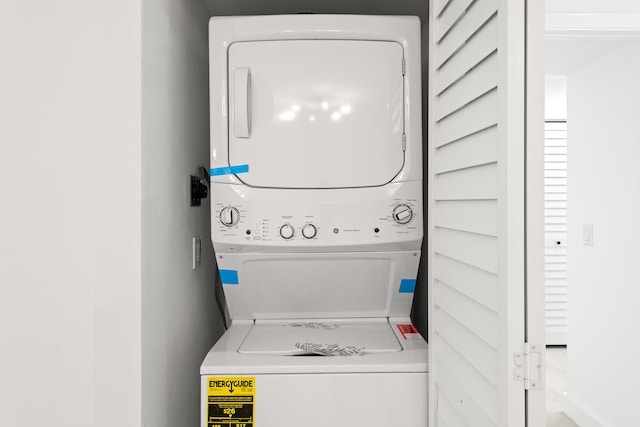 clothes washing area with laundry area and stacked washing maching and dryer