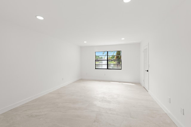 unfurnished room featuring recessed lighting, baseboards, and concrete flooring