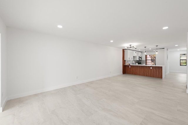 unfurnished living room featuring recessed lighting and baseboards