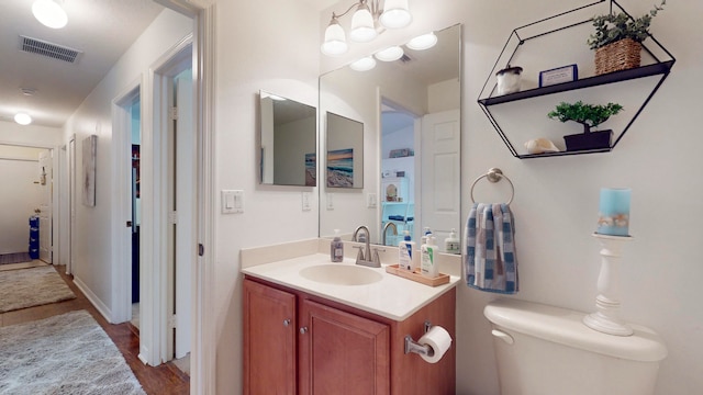 bathroom with hardwood / wood-style floors, toilet, and vanity