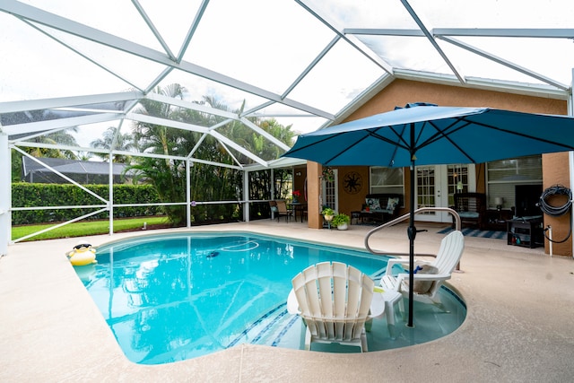 view of pool featuring glass enclosure and a patio