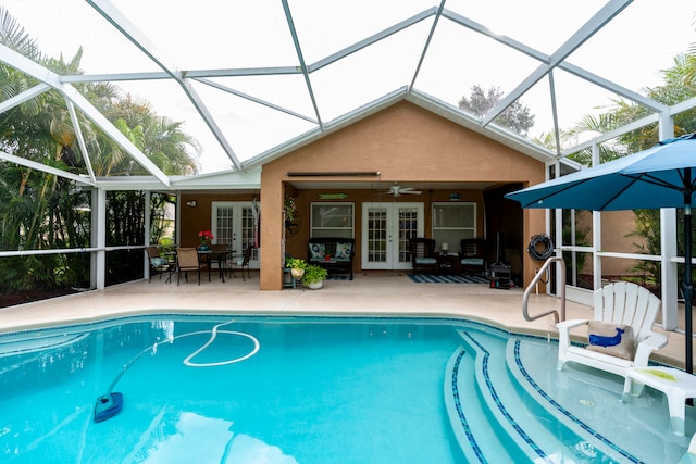 view of pool with french doors, glass enclosure, a patio, and ceiling fan