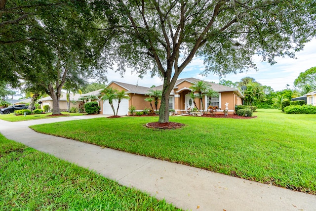 single story home featuring a front yard and a garage