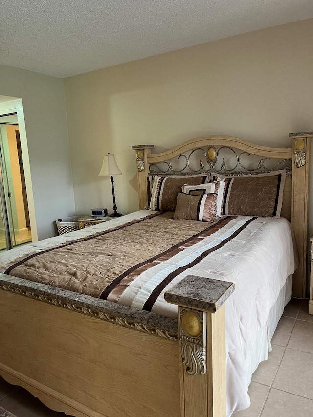 bedroom with light tile patterned floors and a textured ceiling