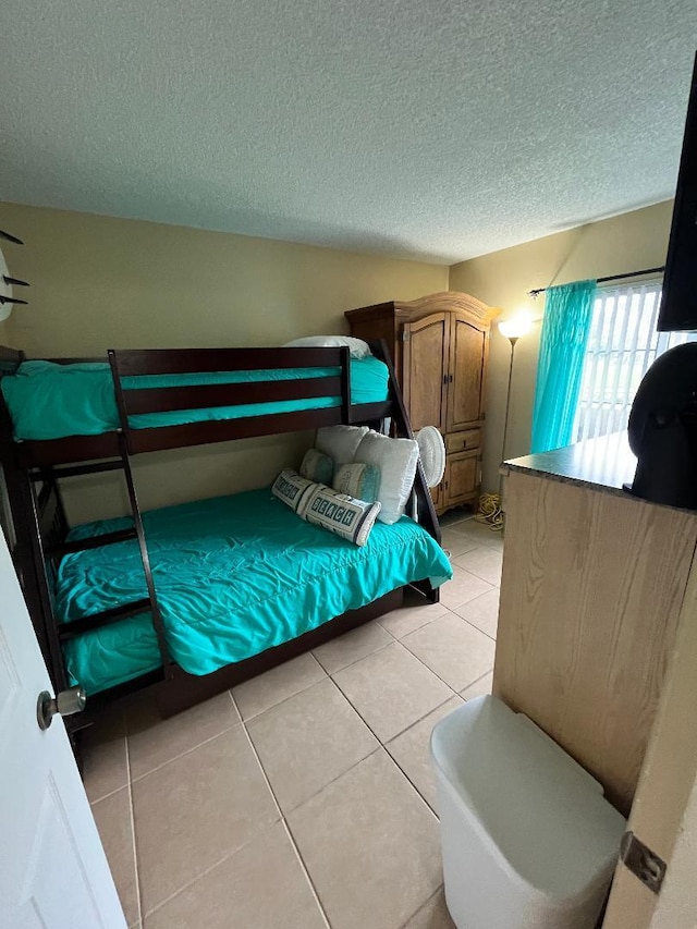 tiled bedroom with a textured ceiling