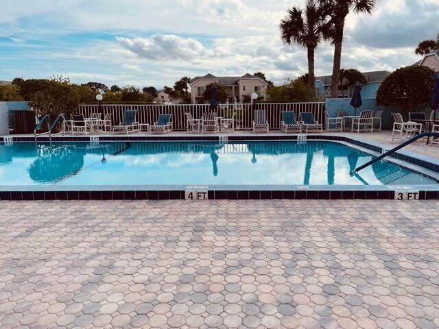pool with a patio area and fence