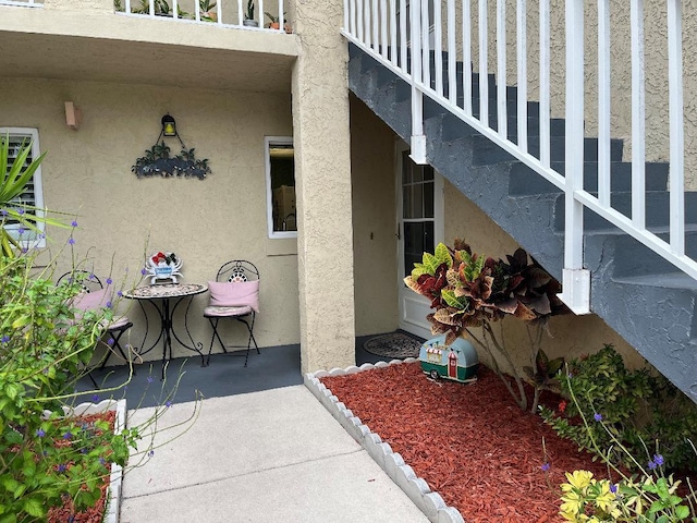 entrance to property with a patio and stucco siding