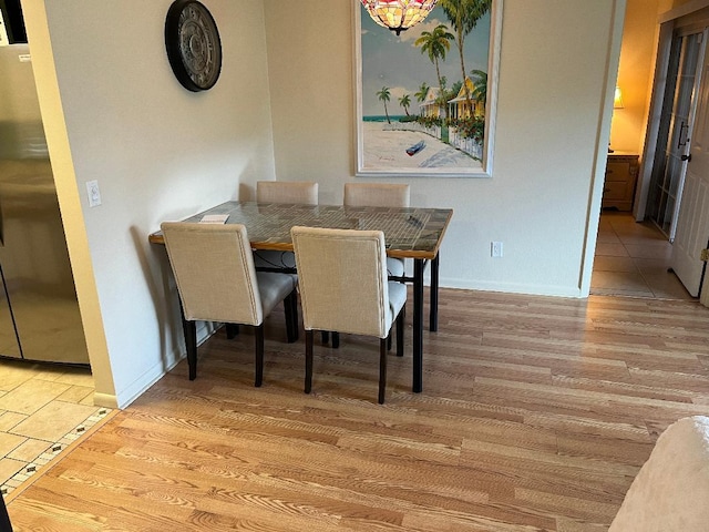dining space featuring wood finished floors and baseboards