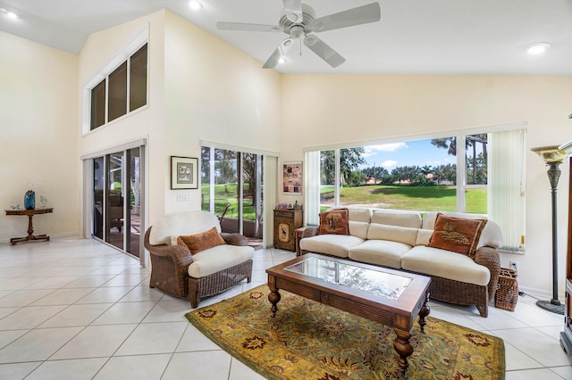 tiled living room with high vaulted ceiling, ceiling fan, and a wealth of natural light