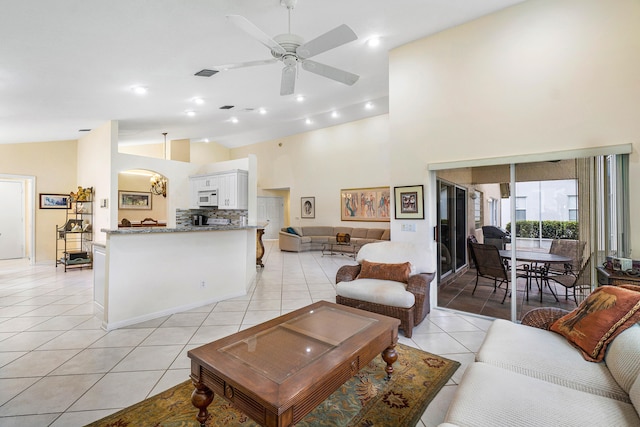 living room with high vaulted ceiling, light tile patterned floors, and ceiling fan