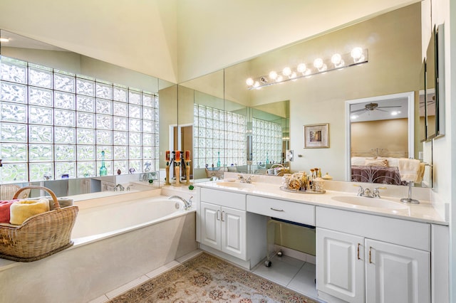 bathroom featuring a tub, vanity, vaulted ceiling, tile patterned flooring, and ceiling fan