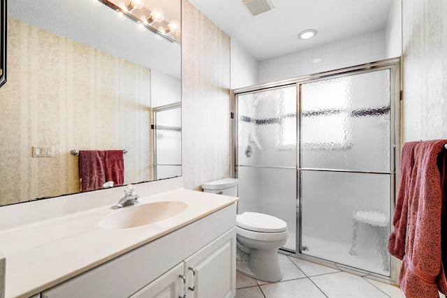 bathroom featuring tile patterned floors, a shower with shower door, toilet, and vanity